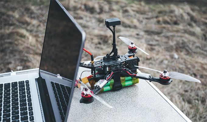 Drone on table sitting next to laptop
